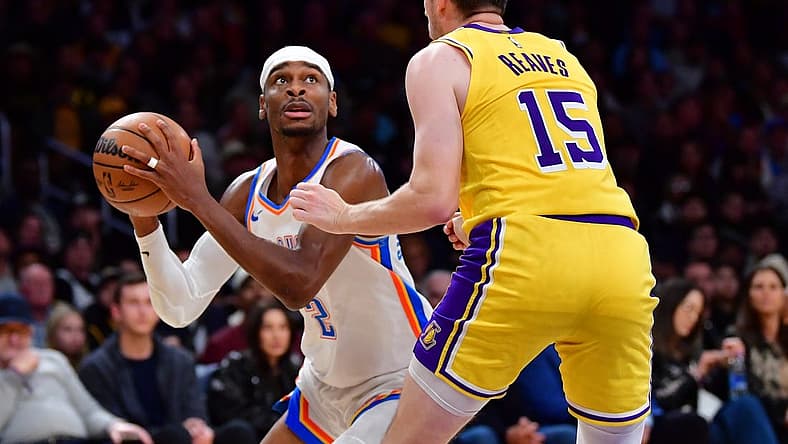 Mar 4, 2024; Los Angeles, California, USA; Oklahoma City Thunder guard Shai Gilgeous-Alexander (2) controls the ball against Los Angeles Lakers guard Austin Reaves (15) during the second half at Crypto.com Arena. Mandatory Credit: Gary A. Vasquez-USA TODAY Sports