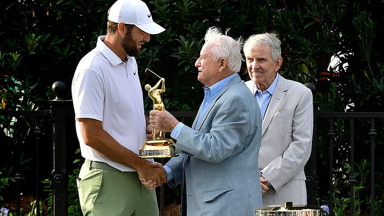 Deane Beman, the PGA Tour Commissioner to oversee the first Players Championship presents Scottie Scheffler his Gold Man tournament trophy as former Commissioner Tim Finchem looks on during the trophy ceremony following the fourth and final round of The Players Championship PGA golf tournament Sunday, March 17, 2024 at TPC Sawgrass in Ponte Vedra Beach, Fla. [Bob Self/Florida Times-Union]