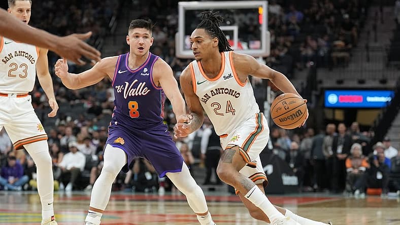 Mar 25, 2024; San Antonio, Texas, USA; San Antonio Spurs guard Devin Vassell (24) drives past Phoenix Suns guard Grayson Allen (8) in the first half at Frost Bank Center. Mandatory Credit: Daniel Dunn-USA TODAY Sports