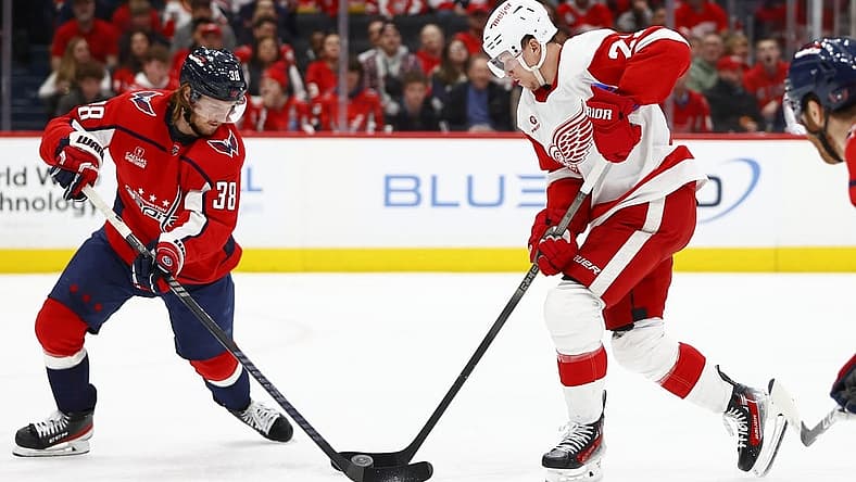 Mar 26, 2024; Washington, District of Columbia, USA; Detroit Red Wings left wing Lucas Raymond (23) battles for the puck with Washington Capitals defenseman Rasmus Sandin (38) during the second period at Capital One Arena. Mandatory Credit: Amber Searls-USA TODAY Sports