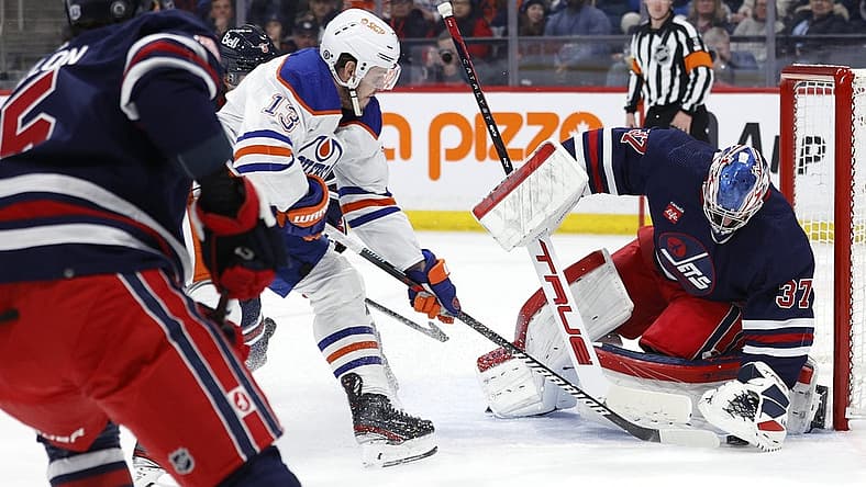 Mar 26, 2024; Winnipeg, Manitoba, CAN; Winnipeg Jets goaltender Connor Hellebuyck (37) covers up a rebound from Edmonton Oilers center Mattias Janmark (13) in the first period at Canada Life Centre. Mandatory Credit: James Carey Lauder-USA TODAY Sports