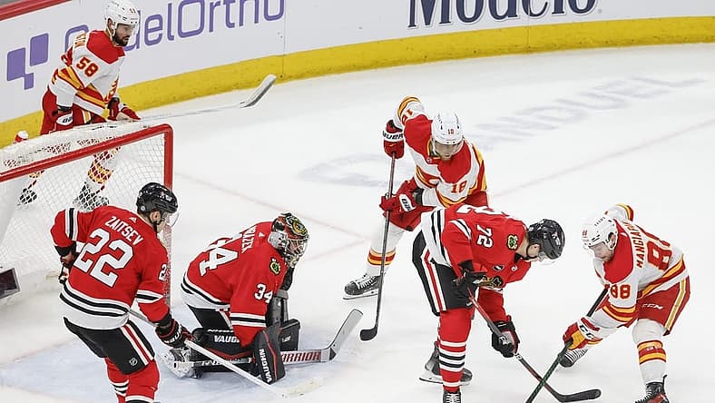 Mar 26, 2024; Chicago, Illinois, USA; Chicago Blackhawks defenseman Alex Vlasic (72) battles for the puck with Calgary Flames left wing Andrew Mangiapane (88) during the second period at United Center. Mandatory Credit: Kamil Krzaczynski-USA TODAY Sports