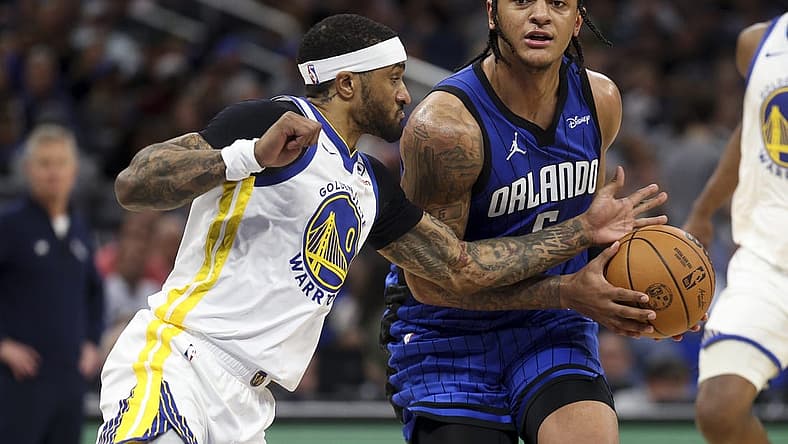 Mar 27, 2024; Orlando, Florida, USA; Orlando Magic forward Paolo Banchero (5) drives the ball past Golden State Warriors guard Gary Payton II (0) in the second quarter at the Kia Center. Mandatory Credit: Nathan Ray Seebeck-USA TODAY Sports