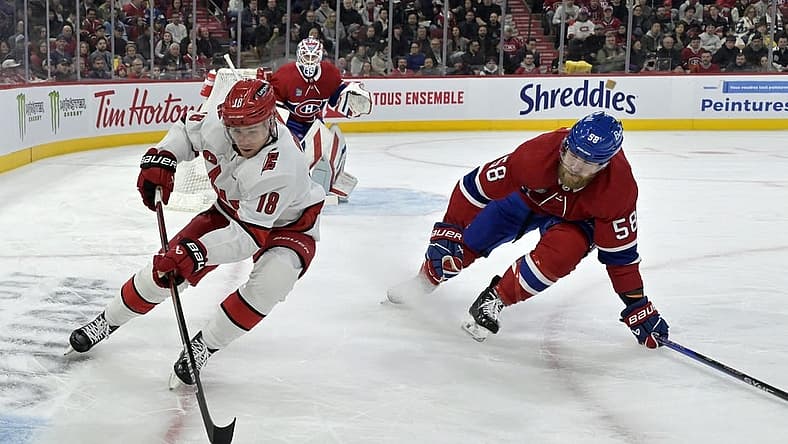 Mar 30, 2024; Montreal, Quebec, CAN; Carolina Hurricanes forward Jack Drury (18) plays the puck and Montreal Canadiens defenseman David Savard (58) defends during the first period at the Bell Centre. Mandatory Credit: Eric Bolte-USA TODAY Sports
