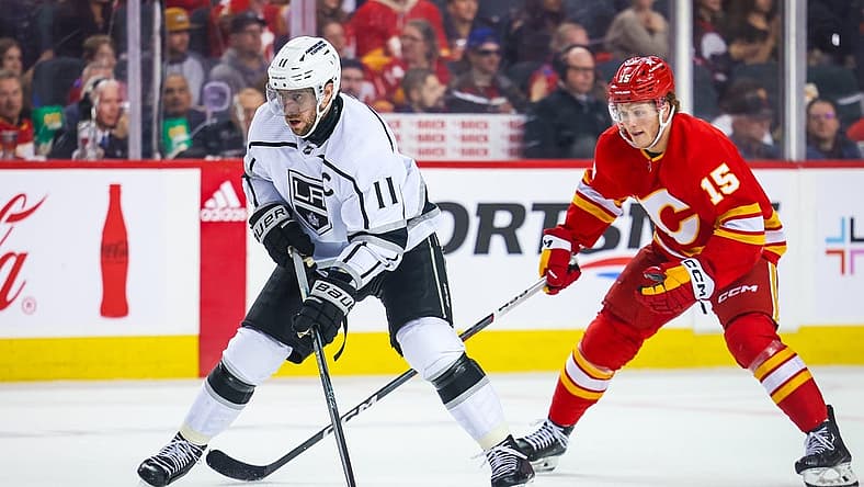 Mar 30, 2024; Calgary, Alberta, CAN; Los Angeles Kings center Anze Kopitar (11) controls the puck against the Calgary Flames during the third period at Scotiabank Saddledome. Mandatory Credit: Sergei Belski-USA TODAY Sports