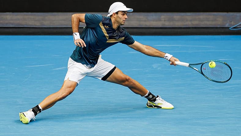 Jan 14, 2024; Melbourne, Victoria, Australia; Facundo Diaz Acosta of Argentina hits a shot against Taylor Fritz of the United States in the first round of the men s singles. Mandatory Credit: Mike Frey-USA TODAY Sports