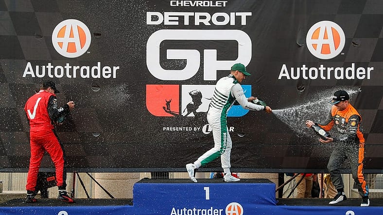 Detroit Grand Prix winner Alex Palou, center, second place Will Power, left, and third place Felix Rosenqvist celebrate their top three finish with champagne in Detroit on Sunday, June 4, 2023.