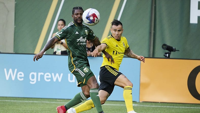 Jul 15, 2023; Portland, Oregon, USA; Columbus Crew midfielder Lucas Zelarrayan (10) crosses the ball during the first half against Portland Timbers forward Dairon Asprilla (27) at Providence Park. Mandatory Credit: Troy Wayrynen-USA TODAY Sports