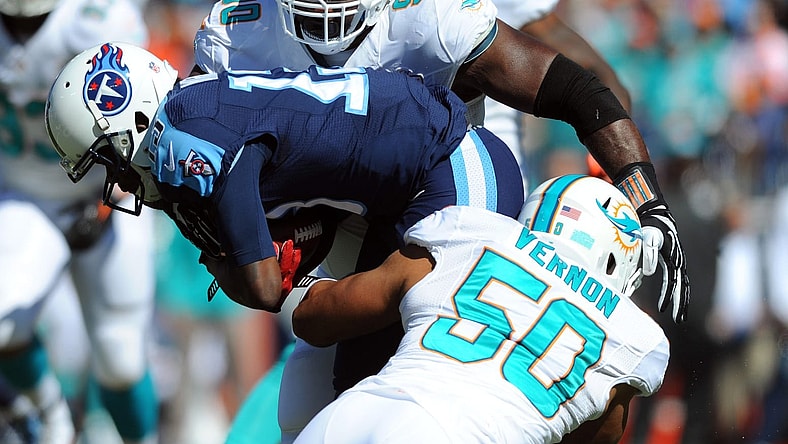 Oct 18, 2015; Nashville, TN, USA; Tennessee Titans receiver Kendall Wright (13) carries the ball as Miami Dolphins defensive tackle Earl Mitchell (90) and defensive end Olivier Vernon (50) defend during the first half a at Nissan Stadium. Mandatory Credit: Christopher Hanewinckel-USA TODAY Sports