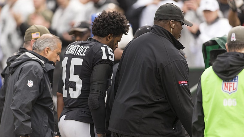 Raiders receiver Michael Crabtree being escorted off field