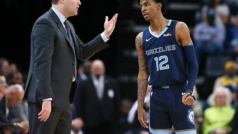 Memphis Grizzlies star Ja Morant talks to head coach during an NBA game.
