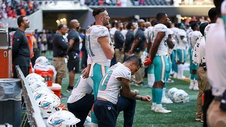 Kenny Stills kneels in protest while the national anthem is played.