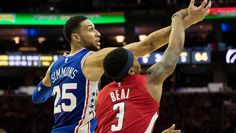 Ben Simmons goes up against Bradley Beal for a rebound during an NBA game.
