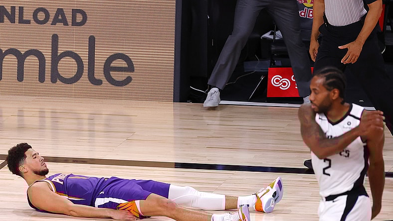 Devin Booker #1 of the Phoenix Suns falls to the ground after scoring the game winning basket against the LA Clippers