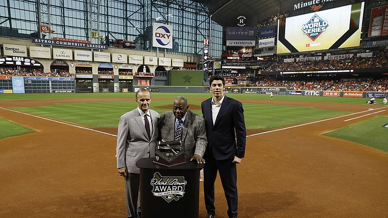 Oct 23, 2019; Houston, TX, USA; Hall of Fame member Hank Aaron (at podium) is joined by Major League Baseball chief baseball officer Joe Torre (left) and Milwaukee Brewers outfielder Christian Yelich (right) for a presentation of the 2019 Hank Aaron Awards before the first inning of game two of the 2019 World Series between the Houston Astros and the Washington Nationals at Minute Maid Park. Mandatory Credit: Matt Slocum/Pool Photo via USA TODAY Sports