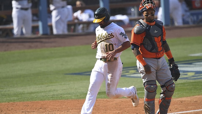 Oct 5, 2020; Los Angeles, California, USA; Oakland Athletics shortstop Marcus Semien (10) scores on a sacrifice fly by right fielder Mark Canha (not pictured) against Houston Astros catcher Martin Maldonado (right) during the fifth inning in game one of the 2020 ALDS at Dodger Stadium. Mandatory Credit: Jayne Kamin-Oncea-USA TODAY Sports
