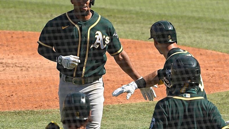 Oct 7, 2020; Los Angeles, California, USA; Oakland Athletics shortstop Marcus Semien (10) is congratulated by second baseman Tommy La Stella (3) after hitting a solo home run off of Houston Astros starting pitcher Jose Urquidy (not pictured) during the fifth inning in game three of the 2020 ALDS at Dodger Stadium. Mandatory Credit: Robert Hanashiro-USA TODAY Sports