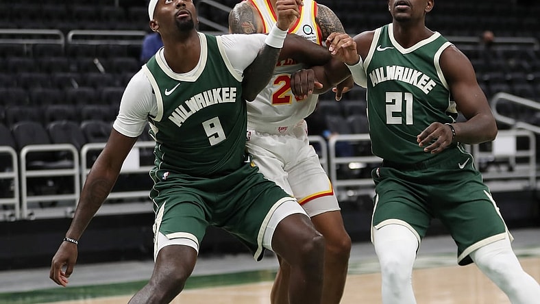 Jan 24, 2021; Milwaukee, WI, USA;  Atlanta Hawks forward John Collins (20) is boxed out by Milwaukee Bucks center Bobby Portis (9) and guard Jrue Holiday (21) at the Bradley Center.  Mandatory Credit: Nick Monroe/Handout Photo via USA TODAY Sports