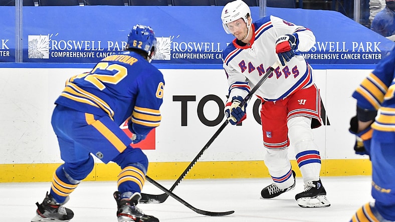Jan 26, 2021; Buffalo, New York, USA; New York Rangers defenseman Jacob Trouba (8) looks to move the puck past Buffalo Sabres defenseman Brandon Montour (62) in the first period of a game at KeyBank Center. Mandatory Credit: Mark Konezny-USA TODAY Sports