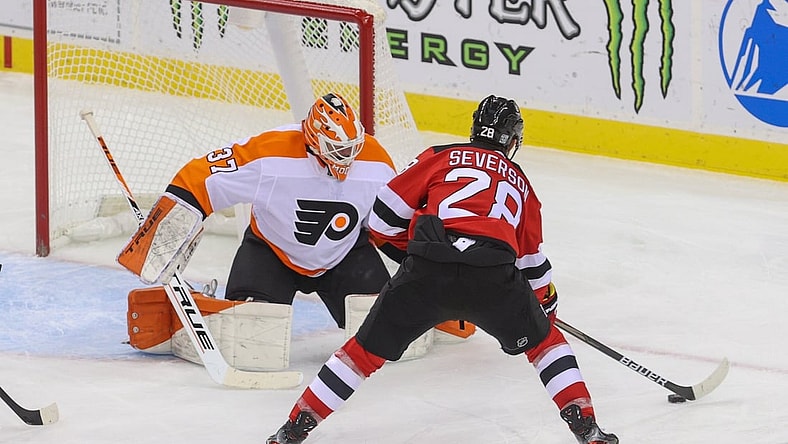 Jan 26, 2021; Newark, New Jersey, USA; New Jersey Devils defenseman Damon Severson (28) skates with the puck while Philadelphia Flyers goaltender Brian Elliott (37) defends his net during the second period at Prudential Center. Mandatory Credit: Ed Mulholland-USA TODAY Sports