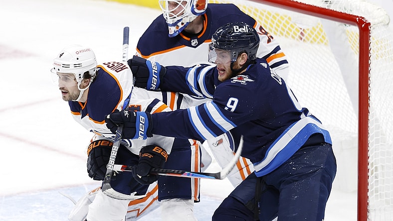 Jan 26, 2021; Winnipeg, Manitoba, CAN; Winnipeg Jets center Andrew Copp (9) checks Edmonton Oilers defenseman Kris Russell (4) in front of Edmonton Oilers goaltender Mikko Koskinen (19) in the second period at Bell MTS Place. Mandatory Credit: James Carey Lauder-USA TODAY Sports