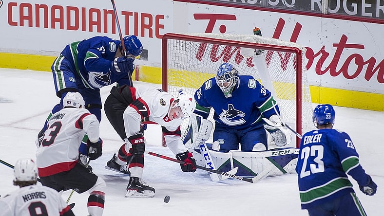 Jan 27, 2021; Vancouver, British Columbia, CAN;  Ottawa Senators forward Brady Tkachuk (7) battles with Vancouver Canucks defenseman Tyler Myers (57) in front of goalie Thatcher Demko (35) in the first period at Rogers Arena. Mandatory Credit: Bob Frid-USA TODAY Sports