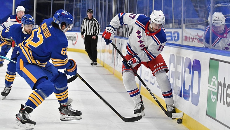 Jan 28, 2021; Buffalo, New York, USA; New York Rangers center Kevin Rooney (17) and Buffalo Sabres defenseman Brandon Montour (62) vie for the puck in the first period at KeyBank Center. Mandatory Credit: Mark Konezny-USA TODAY Sports
