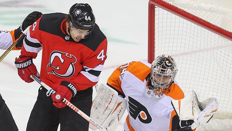 Jan 28, 2021; Newark, New Jersey, USA; Philadelphia Flyers goaltender Carter Hart (79) makes a glove save through a screen by New Jersey Devils left wing Miles Wood (44) during the second period at Prudential Center. Mandatory Credit: Ed Mulholland-USA TODAY Sports