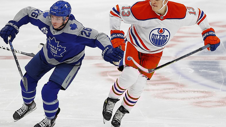Jan 30, 2021; Edmonton, Alberta, CAN; Toronto Maple Leafs forward Jimmy Vesey (26) and Edmonton Oilers forward Jesse Puljujarvi (13) chase a loose puck during the second period at Rogers Place. Mandatory Credit: Perry Nelson-USA TODAY Sports