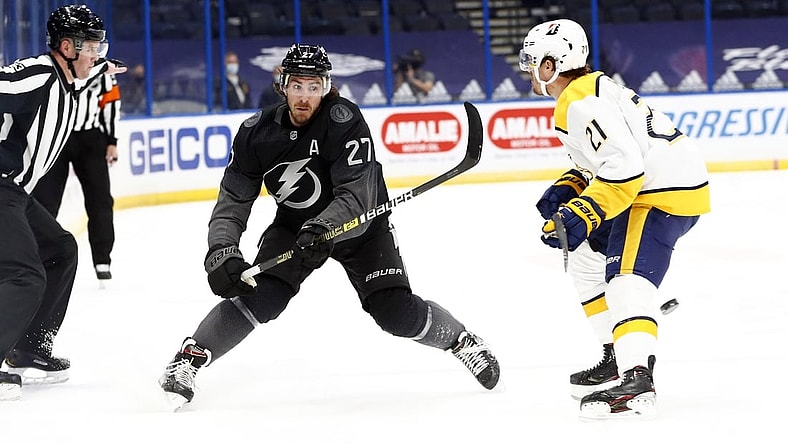 Jan 30, 2021; Tampa, Florida, USA; Tampa Bay Lightning defenseman Ryan McDonagh (27) passes the puck as Nashville Predators center Nick Cousins (21) defends during the first period at Amalie Arena. Mandatory Credit: Kim Klement-USA TODAY Sports