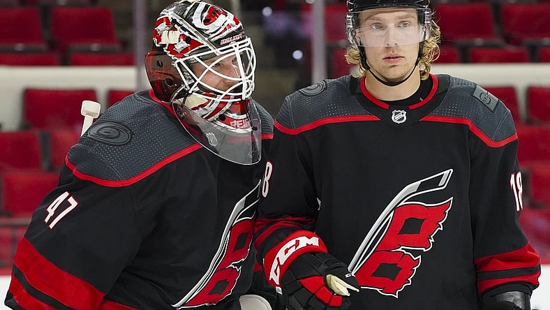 Jan 30, 2021; Raleigh, North Carolina, USA;  Carolina Hurricanes goaltender James Reimer (47) and center Ryan Dzingel (18) celebrate there win against the Dallas Stars at PNC Arena. Mandatory Credit: James Guillory-USA TODAY Sports
