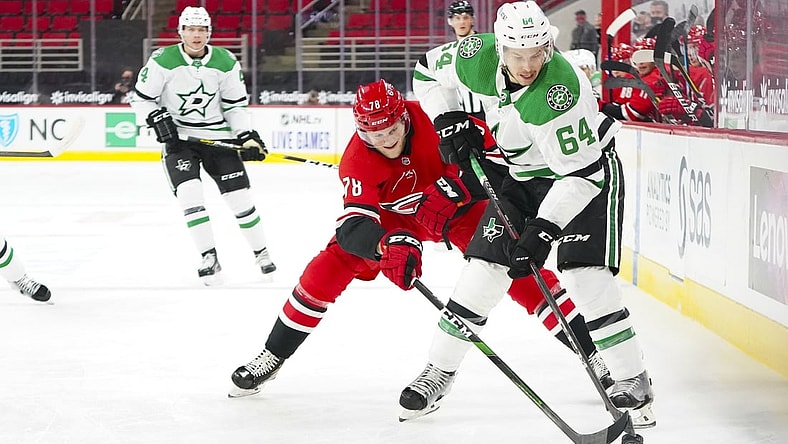 Jan 31, 2021; Raleigh, North Carolina, USA;  Dallas Stars center Tanner Kero (64) tries to control the puck against Carolina Hurricanes center Steven Lorentz (78) at PNC Arena. Mandatory Credit: James Guillory-USA TODAY Sports