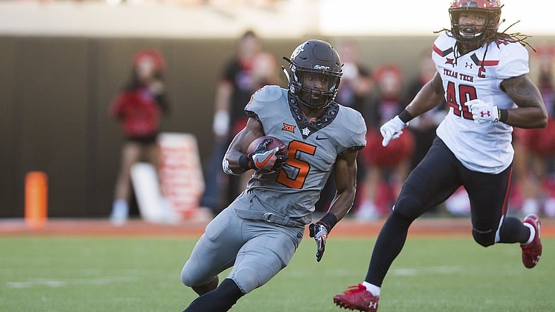 Sep 22, 2018; Stillwater, OK, USA;  Oklahoma State Cowboys cornerback Kemah Siverand (5) runs the ball as Texas Tech Red Raiders linebacker Dakota Allen (40) closes in during the game at Boone Pickens Stadium. Mandatory Credit: Brett Rojo-USA TODAY Sports