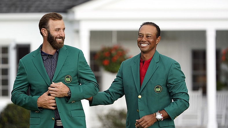 Nov 15, 2020; Augusta, Georgia, USA; 2019 Masters champion Tiger Woods presents Dustin Johnson with the green jacket after winning The Masters golf tournament at Augusta National GC. Mandatory Credit: Michael Madrid-USA TODAY Sports