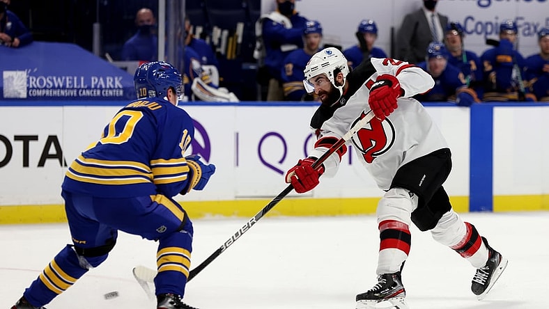 Jan 30, 2021; Buffalo, New York, USA;  Buffalo Sabres defenseman Henri Jokiharju (10) tries to block a shot on goal by New Jersey Devils right wing Kyle Palmieri (21) during the third period at KeyBank Center. Mandatory Credit: Timothy T. Ludwig-USA TODAY Sports