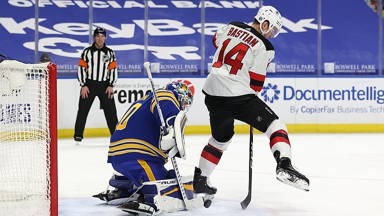 Jan 31, 2021; Buffalo, New York, USA; New Jersey Devils right wing Nathan Bastian (14) deflects a shot on Buffalo Sabres goaltender Carter Hutton (40) during the third period at KeyBank Center. Mandatory Credit: Timothy T. Ludwig-USA TODAY Sports