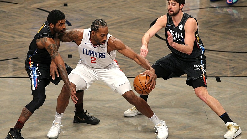 Feb 2, 2021; Brooklyn, New York, USA; Los Angeles Clippers small forward Kawhi Leonard (2) controls the ball against Brooklyn Nets point guard Kyrie Irving (L) and small forward Joe Harris (R) during the first quarter at Barclays Center. Mandatory Credit: Brad Penner-USA TODAY Sports