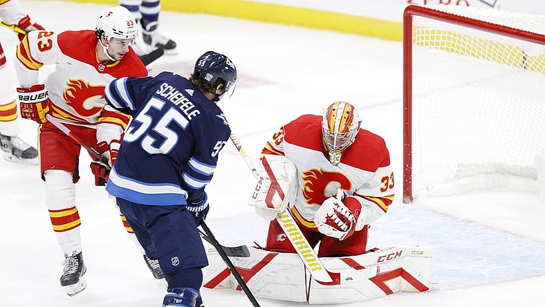 Feb 2, 2021; Winnipeg, Manitoba, CAN.;  Winnipeg Jets center Mark Scheifele (55) looks for a rebound after a shot on Calgary Flames goaltender David Rittich (33) in the second period at Bell MTS Place. Mandatory Credit: James Carey Lauder-USA TODAY Sports