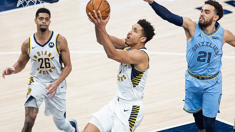 Feb 2, 2021; Indianapolis, Indiana, USA; Indiana Pacers guard Malcolm Brogdon (7) shoots the ball wheel Memphis Grizzlies guard Tyus Jones (21) defends in the third quarter at Bankers Life Fieldhouse. Mandatory Credit: Trevor Ruszkowski-USA TODAY Sports