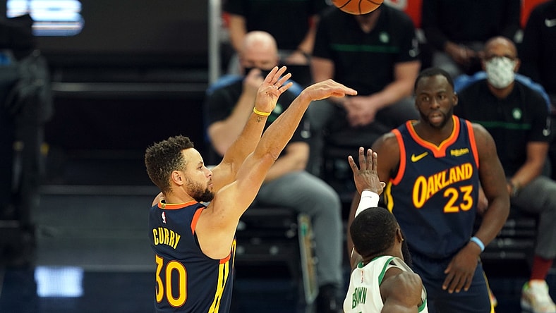 Feb 2, 2021; San Francisco, California, USA; Golden State Warriors guard Stephen Curry (30) hits a 3 pointer over Boston Celtics guard Jaylen Brown (7) during the first quarter at Chase Center. Mandatory Credit: Darren Yamashita-USA TODAY Sports