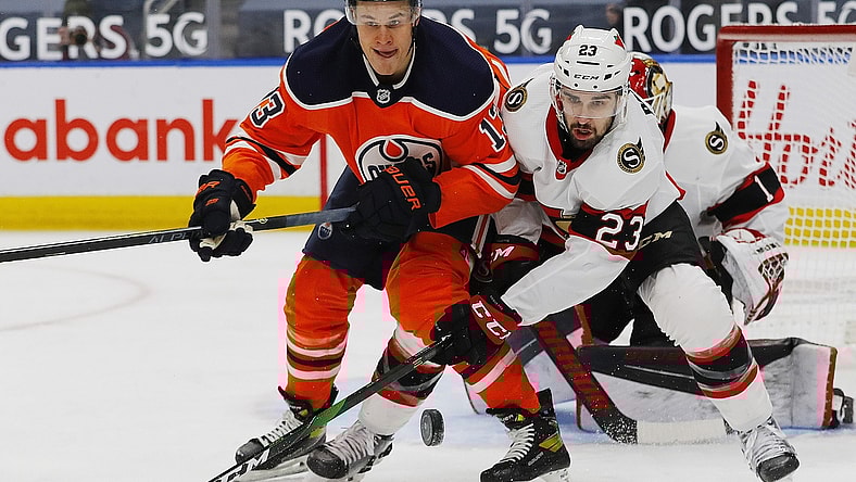 Feb 2, 2021; Edmonton, Alberta, CAN; Edmonton Oilers forward Jesse Puljujarvi (13) and Ottawa Senators forward Cedric Paquette (23) look for a loose puck during the first period at Rogers Place. Mandatory Credit: Perry Nelson-USA TODAY Sports