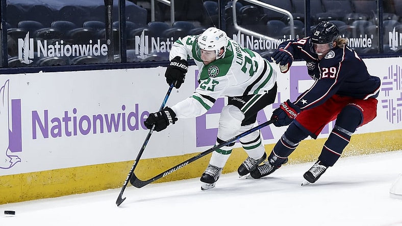 Feb 4, 2021; Columbus, Ohio, USA; Dallas Stars defenseman Esa Lindell (23) passes the puck against Columbus Blue Jackets right wing Patrik Laine (29) in the first period at Nationwide Arena. Mandatory Credit: Aaron Doster-USA TODAY Sports