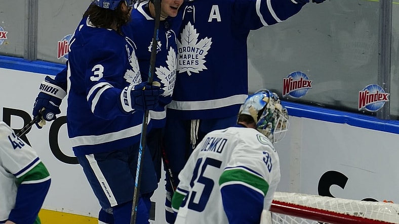 Feb 4, 2021; Toronto, Ontario, CAN; Toronto Maple Leafs forward Auston Matthews (34) celebrates his second goal of the game against Vancouver Canucks goaltender Thatcher Demko (35) with Toronto Maple Leafs forward Zach Hyman (11) and defenseman Justin Holl (3) during the second period at Scotiabank Arena. Mandatory Credit: John E. Sokolowski-USA TODAY Sports