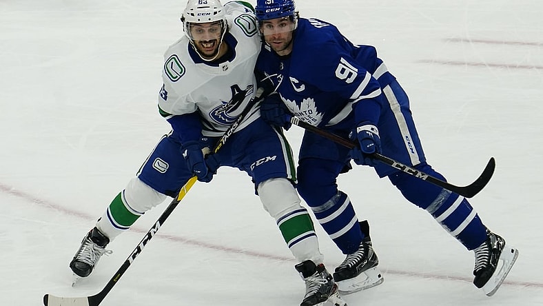 Feb 4, 2021; Toronto, Ontario, CAN; Vancouver Canucks defenseman Jalen Chatfield (63) and Toronto Maple Leafs forward John Tavares (91) battle for position during the third period at Scotiabank Arena. Toronto defeated Vancouver. Mandatory Credit: John E. Sokolowski-USA TODAY Sports