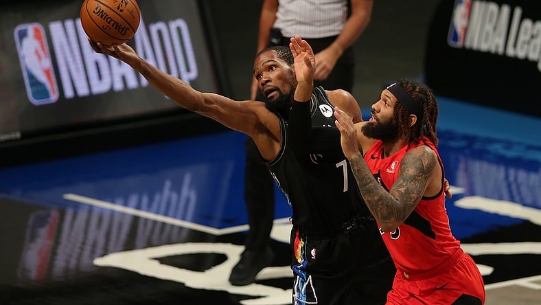 Feb 5, 2021; Brooklyn, New York, USA; Brooklyn Nets power forward Kevin Durant (7) tries to keep a ball in bounds against Toronto Raptors small forward DeAndre' Bembry (95) during the first quarter at Barclays Center. Mandatory Credit: Brad Penner-USA TODAY Sports