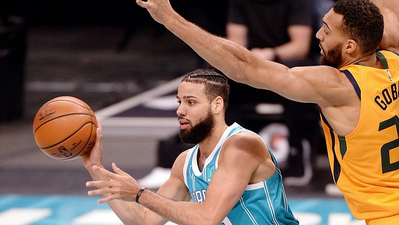 Feb 5, 2021; Charlotte, North Carolina, USA; Charlotte Hornets guard forward Caleb Martin (10) passes as he is defended by Utah Jazz center Rudy Gobert (27) during the first half at the Spectrum Center. Mandatory Credit: Sam Sharpe-USA TODAY Sports