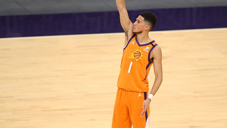 Feb 5, 2021; Phoenix, Arizona, USA; Phoenix Suns guard Devin Booker (1) follows through on a three pointer against the Detroit Pistons in the second half at Phoenix Suns Arena. Mandatory Credit: Mark J. Rebilas-USA TODAY Sports