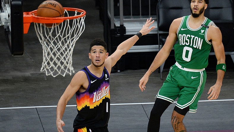 Feb 7, 2021; Phoenix, Arizona, USA; Boston Celtics forward Jayson Tatum (0) makes a shot against Phoenix Suns guard Devin Booker (1) during the second half at Phoenix Suns Arena. Mandatory Credit: Joe Camporeale-USA TODAY Sports