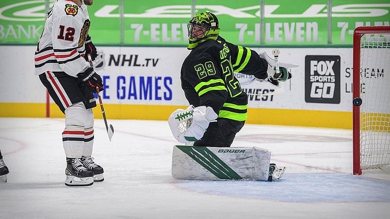 Feb 7, 2021; Dallas, Texas, USA; Chicago Blackhawks left wing Alex DeBrincat (12) watches a shot get past Dallas Stars goaltender Jake Oettinger (29) during the first period at the American Airlines Center. Upon review the call on the ice was no goal. Mandatory Credit: Jerome Miron-USA TODAY Sports