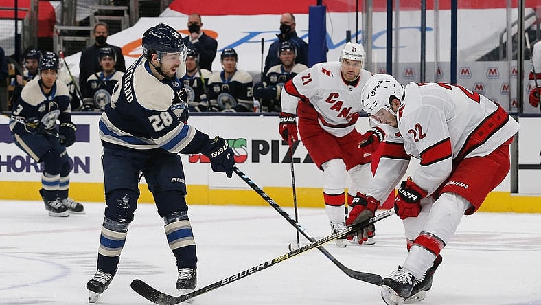 Feb 7, 2021; Columbus, Ohio, USA; Carolina Hurricanes defenseman Brett Pesce (22) knocks down the pass attempt of Columbus Blue Jackets right wing Oliver Bjorkstrand (28) during the first period at Nationwide Arena. Mandatory Credit: Russell LaBounty-USA TODAY Sports